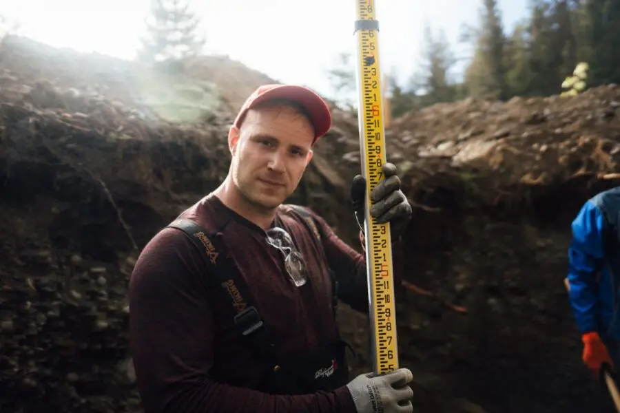 Proseptix ROWP practitioner measuring a soil test pit with a grade rod