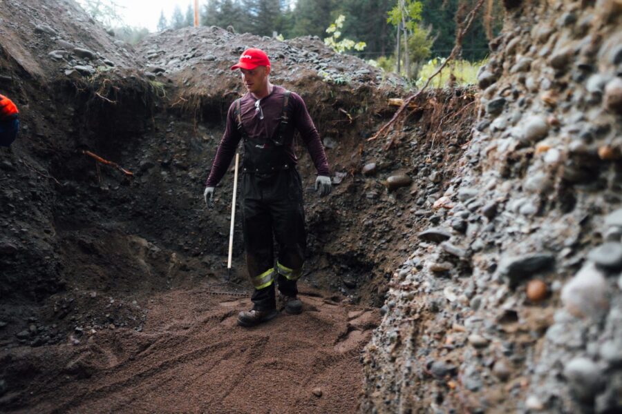 Proseptix practitioner checking soil layers in a deep site assessment pit